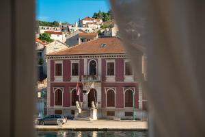 a red building with a car parked in front of it at Bed & Breakfast Blanc in Pučišća