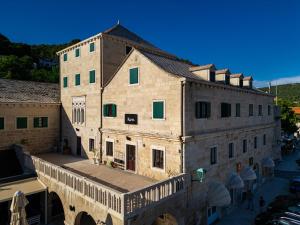 a large stone building with a bridge over a street at Bed & Breakfast Blanc in Pučišća