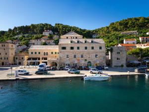 a group of cars parked in a harbor with a boat at Bed & Breakfast Blanc in Pučišća