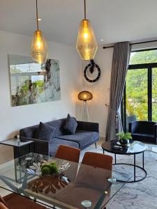 un salon avec un canapé bleu et une table en verre dans l'établissement Luxury Apartment - Embassy Gardens, à Accra