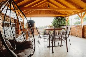 a porch with chairs and a table and a wooden roof at Vinný sklep in Moravská Nová Ves