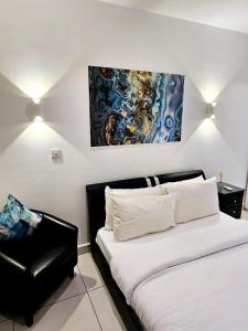 une chambre avec un lit et un tableau au mur dans l'établissement Luxury Apartment - Embassy Gardens, à Accra