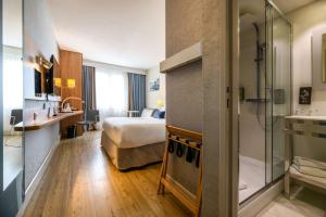 a hotel room with a bed and a shower at Best Western Plus Ajaccio Amirauté in Ajaccio