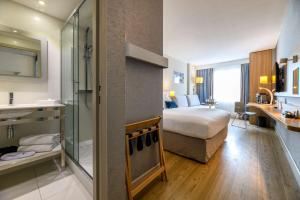 a hotel room with a bed and a bathroom at Best Western Plus Ajaccio Amirauté in Ajaccio