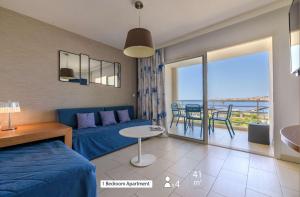 a living room with a blue couch and a table at Best Western Plus Ajaccio Amirauté in Ajaccio