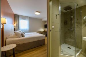 a hotel room with a bed and a shower at Best Western Plus Ajaccio Amirauté in Ajaccio