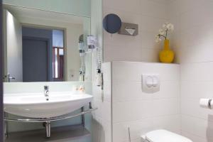 a white bathroom with a sink and a mirror at Best Western Plus Ajaccio Amirauté in Ajaccio