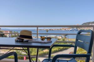 a hat and glasses sitting on a table on a balcony at Best Western Plus Ajaccio Amirauté in Ajaccio