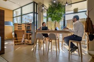 a man and a woman sitting at a table at Best Western Plus Ajaccio Amirauté in Ajaccio