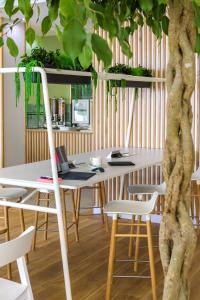 a table and chairs with a tree in a room at Best Western Plus Ajaccio Amirauté in Ajaccio