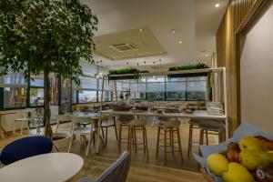 a restaurant with tables and chairs and a cafeteria at Best Western Plus Ajaccio Amirauté in Ajaccio