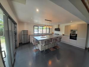 a large kitchen with a table and chairs in it at Maison Tevaiana in Punaauia