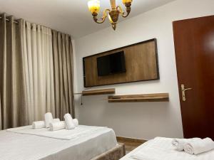 a hotel room with two beds and a flat screen tv at DD Apartment in Berat