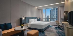 a hotel room with a bed and a couch at Crowne Plaza Hangzhou Riverside by IHG in Hangzhou