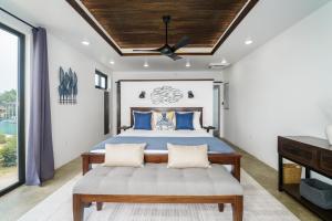 una camera da letto con un letto e un ventilatore a soffitto di Spacious 4-Bed Villa in Placencia Village w Pool a Placencia Altre 45 foto