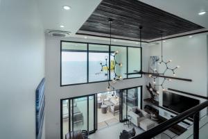 un soggiorno con ampie finestre e un lampadario a braccio di Spacious 4-Bed Villa in Placencia Village w Pool a Placencia