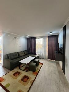 a living room with a couch and a table at Orion Villa 1 in Batumi