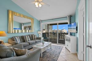 a living room with a couch and a tv at Baywatch Unit F10 in Pensacola Beach