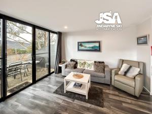 a living room with a couch and a table at Bundarra One in Jindabyne