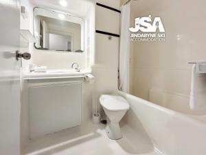 a white bathroom with a sink and a toilet at Bundarra One in Jindabyne +8 photos