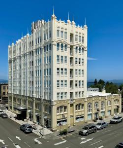 a large white building with cars parked in a parking lot at Norblad Hotel in Astoria, Oregon