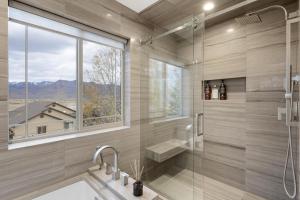 a bathroom with a shower and a sink and a window at Heber Hideaway Exquisite Home with Hot Tub in Heber City +42 photos