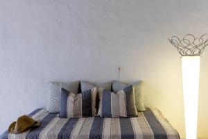 a bed with blue and white pillows in a bedroom at Platanos Cycladic house in Panormos