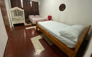 a bedroom with two beds and a clock on the wall at Casa Juayúa in Juayúa