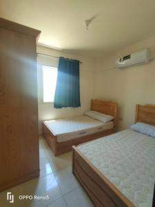 شاليهات مرسى مطروح قريه سورتيلاج السياحيه في مرسى مطروح: غرفة نوم بها سريرين ونافذة