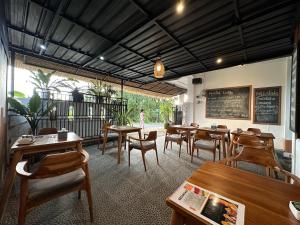 姆杜克Dong Paloh Hostel的一间带木桌和椅子以及黑板的餐厅