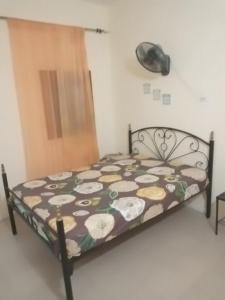 a bedroom with a bed with a floral comforter at La paix bis in Saint-Louis +7 photos