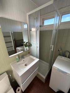a white bathroom with a sink and a shower at Grand large Appartement terrasse front de mer Barcarès in Le Barcarès +4 photos