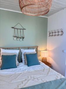 a bedroom with a large bed with blue pillows at Grand large Appartement terrasse front de mer Barcarès in Le Barcarès