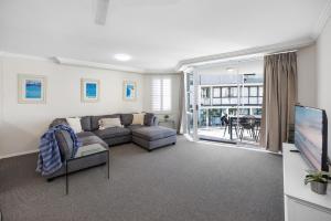 a living room with a couch and a tv at 3 Bedroom Apartment with Lift in Caloundra