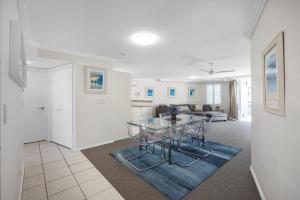 a dining room and living room with a glass table at 3 Bedroom Apartment with Lift in Caloundra