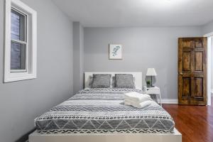 a bed in a white room with a window at Pet-Friendly Apartment on Ossington Ave in Toronto