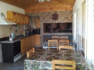eine Küche mit einem Tisch mit Stühlen und einem Herd in der Unterkunft Complejo Rancho Aparte in Villa Rumipal + 15 Fotos