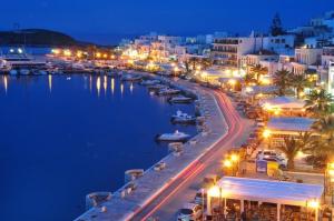 une ville de nuit avec des bateaux dans un port dans l'établissement Hotel Coronis, à Naxos Chora