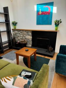a living room with a couch and a fireplace at Luxurious Kiwiana Raumati Beachfront Home in Paraparaumu