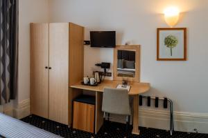 ein Hotelzimmer mit einem Schreibtisch und einem Stuhl in der Unterkunft The Melita in London