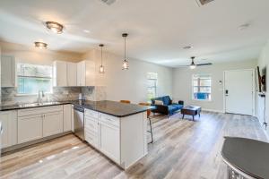 a kitchen with white cabinets and a living room at Remodeled Tulsa House with Yard about 4 Mi to Downtown! in Tulsa +21 photos
