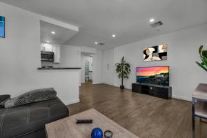a living room with a couch and a flat screen tv at Stylish One-Bedroom Retreat with Central AC & Free Parking in the Heart of Hollywood in Los Angeles