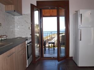 a kitchen with a sliding glass door to a balcony at Archontiko Nikolaou Keramidi in Keramídhion