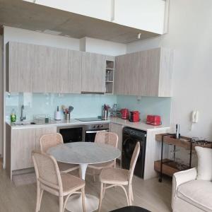 a kitchen with a table and chairs in a room at HOM I Espectacular Loft con Vista al Mar en Valparaiso in Valparaíso