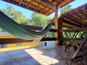 a hammock on a house with a roof at Carneiro Caiçara chalés- Casinhas aconchegantes em Ubatuba in Ubatuba