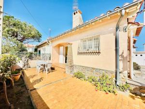 un patio con tavolo e sedie di fronte a una casa di Canet plage Maison de vacances 2 Chambres et jardin a Canet-en-Roussillon