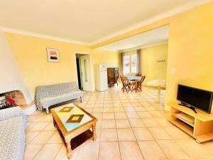 un soggiorno con un divano e una TV di Canet plage Maison de vacances 2 Chambres et jardin a Canet-en-Roussillon
