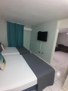 a room with two beds and a flat screen tv at beach 1 bedroom 23 in Ocho Rios