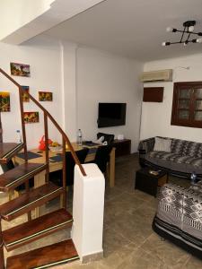 a living room with a staircase and a couch at Tchada- Duplex in Bissau