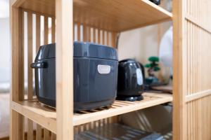 a blue appliance on a shelf in a wooden cabinet at Saku House Jujo in Tokyo